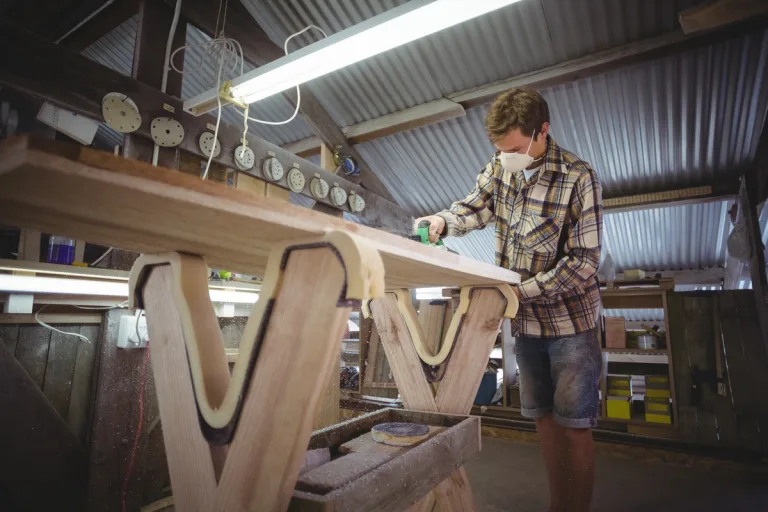 Man using modified planer in the surfboard workshop