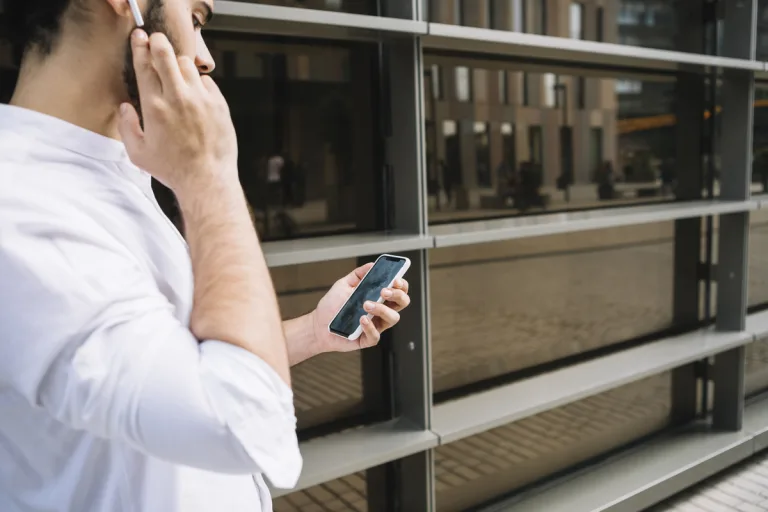 biznesmen-robi-wideokonferencji-na-smartfonie-i-rozmawia-z-urzadzeniem-bluetooth-handsfree(1)